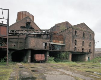 View from SW of S gables of brick-built Hopper (Left) and Old Washer (right), prior to restoration.  The view also shows the railway lines emerging from the lower level of the pit-head complex.