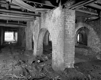 Newtongrange, Lady Victoria Colliery, Pithead Building (Tub Circuit, Tippler Section, Picking Tables)
Diagonal interior view from NE looking through arcades of brick arches separating the railway sidings passing under the colliery's surface buildings.  Wagons were filled from conveyors and hoppers in the floors above, which also housed the Picking Tables