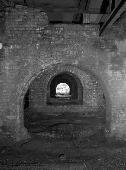 Newtongrange, Lady Victoria Colliery, Pithead Building (Tub Circuit, Tippler Section, Picking Tables)
Detailed interior view from E looking through the arcades of brick arches separating the railway sidings passing under the colliery's surface buildings.  Wagons were filled from conveyors and hoppers in the floors above, which contained the Picking Tables