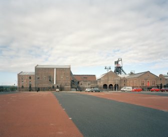 General view of S portion of colliery surface buildings from E following the demolition of the north end of the neighbouring workshops and the construction of a carpark for the museum.