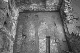 Excavation photograph : floor of tower house basement viewed from above, from N.