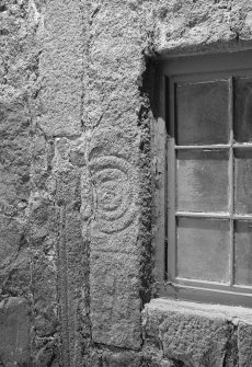 View of face of fragmented Pictish symbol stone, used as lintel above a window at East Balhalgardy Farm.