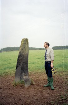 View of rubbing stone from E, with Dr Iain Fraser (RCAHMS) in picture