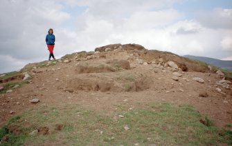 Detail of erosion to SW side of cairn; Mr Angela Gannon (RCAHMS) in picture