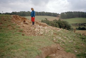 Detail of erosion to SW side of cairn; Mrs Angela Gannon (RCAHMS) in picture