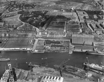 Glasgow, general view, showing Robinson Dunn and Co. Ltd. Partick Saw Mills and Meadowside Granary, Linthouse, Govan, Lanarkshire, Scotland, 1930.  Oblique aerial photograph taken facing south. Oblique aerial photograph  taken facing north. This image has been produced from a marked negative.