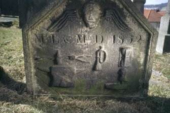 View of headstone dated 1750 and 1852 showing anvil, trumpet and hourglass, Kilsyth Burial Ground.