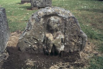 View of partly buried headstone showing skeleton and sexton's tools, Roberton Parish churchyard.