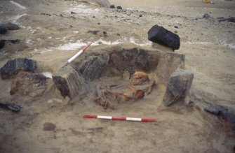 Excavation photographs: Bronze Age cist burial under excavation. Includes detailed views of skeleton and pottery vessel.