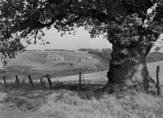 Distant view of Crichton Castle from W with a tree in the foreground
