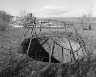 Detailed view from E of mouth of pot of old lime kiln, with lime works visible in background