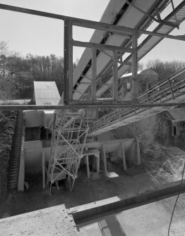 View from N at middle level of shaft kilns, showing the conveyor taking crushed limestone to the former kilns for storage.  The base of the crusher is visible, as is a surviving portion of one of the old conveyors used to charge the shaft kilns when they were in operation