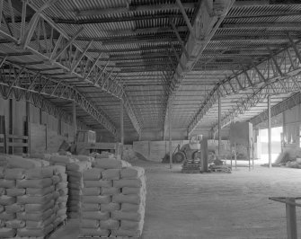 Interior view from SW across lime store (a former aircraft hangar), revealing its latticed steel frame