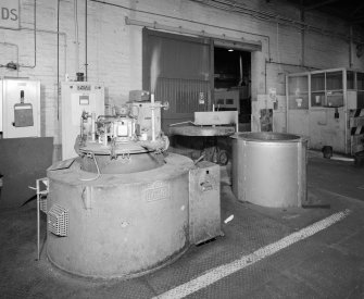 Motherwell, Craigneuk Street, Anderson Boyes
Heat Treatment (Dept. 12, west bay built 1945): Interior view from north west in the west bay of one of three Wild Barfield Carbo-drip heating furnaces, and cooling pot (right).  The furnace is fuelled by clean endothermic gas (produced by a generator on the other side of the bay), and heat treatment is required for the hardening of components of machines, such as gears.