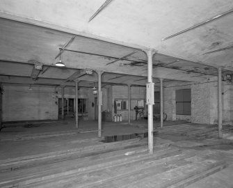 Interior.
View from NE within high mill at ground floor level, showing vaulted cast-iron framed fire-proof structure, and office added after conversion of site to bonded (whisky) warehouse.
