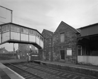 View from north west of rubble-built station offices, and wooden overbridge (left)