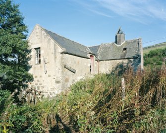 General view of mill from E, showing mill range (left) and kiln (right), also showing the water wheel on the SE gable of the mill.