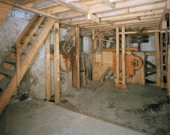 Interior.
View at ground-floor level, showing winnowing machine (centre right), with machinery of gear cupboard partially visible behind.