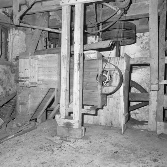 Interior.
View of ground-floor level, showing winnowing machine (centre), with machinery of gear cupboard partially visible behind.