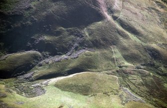 Oblique aerial view of Ewes Doors centred on the remains of a possible Roman watch tower, linear earthworks and old roads, taken from the NE.