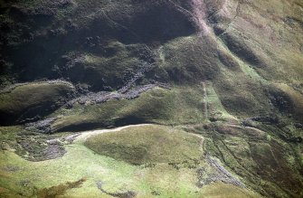 Oblique aerial view of Ewes Doors centred on the remains of a possible Roman watch tower and linear earthworks, taken from the NE.