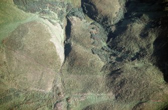 Oblique aerial view of Ewes Doors centred on the remains of a possible Roman watch tower and linear earthworks, taken from the NW.