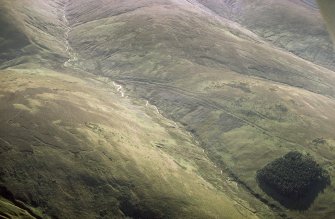 Oblique aerial view of Ewes Doors centred on the remains of hollow-ways, an old road, a possible Roman road, a linear earthwork and a possible Roman watch tower, taken from the NE.