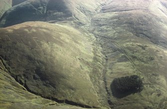 Oblique aerial view of Ewes Doors centred on the remains of hollow-ways, an old road, a possible Roman road, a linear earthwork and a possible Roman watch tower, taken from the NNE.