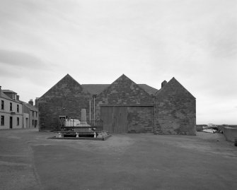 General view from W showing three bays forming fish processing works, the S (right) bay still containing one of four original smoke kilns.  The plaque in the gable of the central bay contains the date 1896, and the initials JSB (John S Boyle), who erected the building during the herring boom