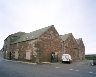 General view from NW, showing old granary (left), and three bays of fish processing works (right)