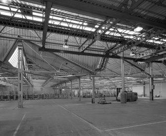 Interior view from north west within Final Assembly Area, showing the point at which the former (north-lit) textile mill building ends and the new 1980 building begins.
