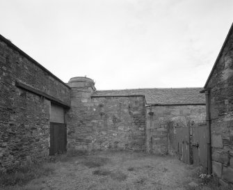 Detailed view from SW of base of former chimney, situated at the NE end of the SE courtyard, adjacent to the threshing barn (left).