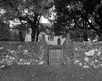 General view from E showing entrance gate and church beyond