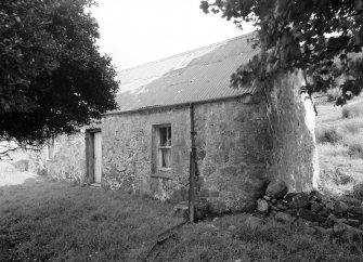 View from SW of front elevation showing harled rubble walls and corrugated iron roof.