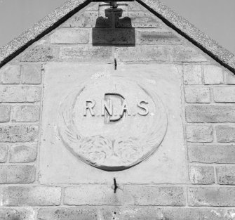 Donibristle airfield, detail of date plaque on gable end of South entrance (building D) to officers' mess.  The plaque has been made of moulded concrete.