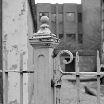 Detail of cast iron finialed gate post and railings outside showroom.