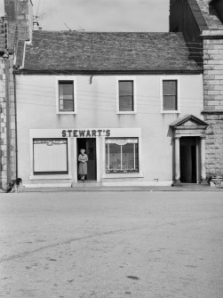 View of 18 North Main Street, Wigtown, from south east, showing shopkeeper at Stewart's shoe shop.
