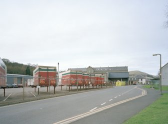 Distant view of the mill from SE, with Edinburgh Woollen Mills trailers in the foreground.