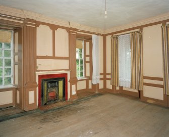 Interior. View of first floor South room/ drawing room from North showing fireplace flanked by giant fluted pilasters, panelling and windows
