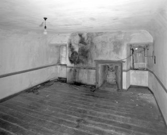 Interior. View of second floor South room from North showing coombed ceiling and fireplace