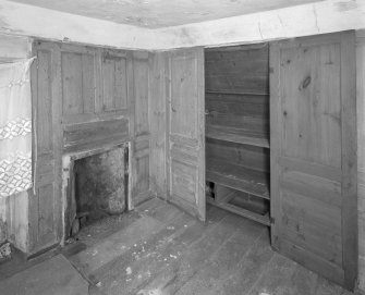 Interior. View of second floor East room/housekeepers room from North showing fireplace and fitted cupboards.