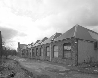 Oblique view from NE of SE side of main block of mill.