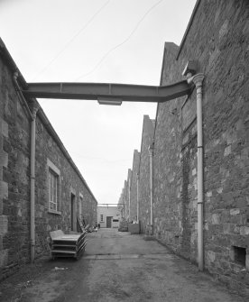 Peebles, March Street, March Street Mills
View from north east in passage between north block of works (left) and central block (right), the latter containing the former engine and boiler houses.  A cast-iron beam spans the gap between the two blocks