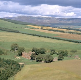 Oblique aerial view centred on Edzell Castle looking NE showing mountains in the background.