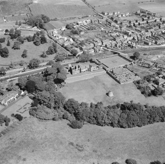 Oblique aerial view of Aberdour village, showing Aberdour Castle and dovecot, and St Fillan's Church
