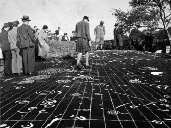 Site photograph : decorated rock and visitors