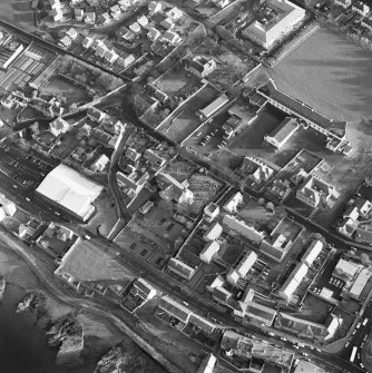 Oblique aerial view of Prestonpans, Kirk Street, Prestongrange Church centred on a church and graveyard, taken from the NW.