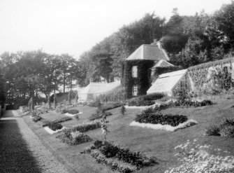 General view of garden house and borders.