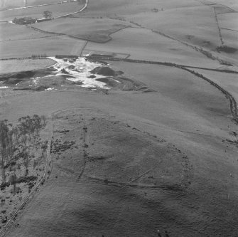 Oblique aerial view centred on the remains of the fort, settlement and cairn, Black Hill, Lesmahagow.