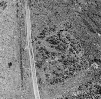 Oblique aerial view centred on the remains of cairn and stone circle, Moss Farm Road, Arran.

